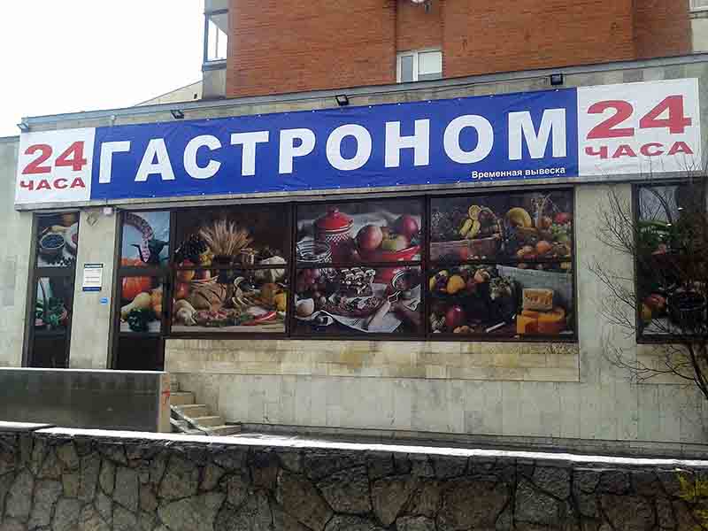 Оклейка витрин перфопленкой и натяжка баннера над витриной.
